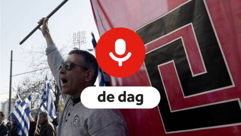 Een neonazie bij een protest met een vlag van de partij in de achtergrond