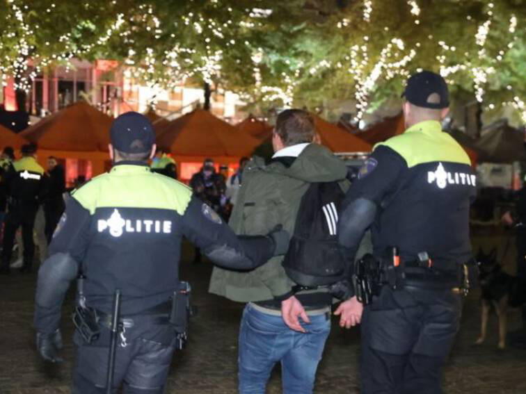 2 politie agenten nemen een verdachte in detentie op een verlaten festival