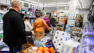 Een supermarkt bij een drukke kassa waar veel verkocht wordt